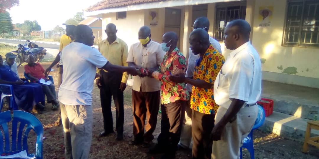 The district officials handing over money to the beneficiaries